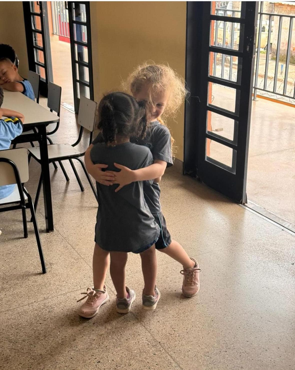 Brown leather key ring with brass metal loops and rivets on wood table.
